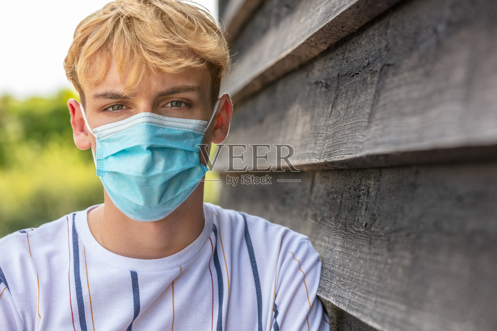 在新冠肺炎病毒大流行期间，戴口罩的男性青年照片摄影图片