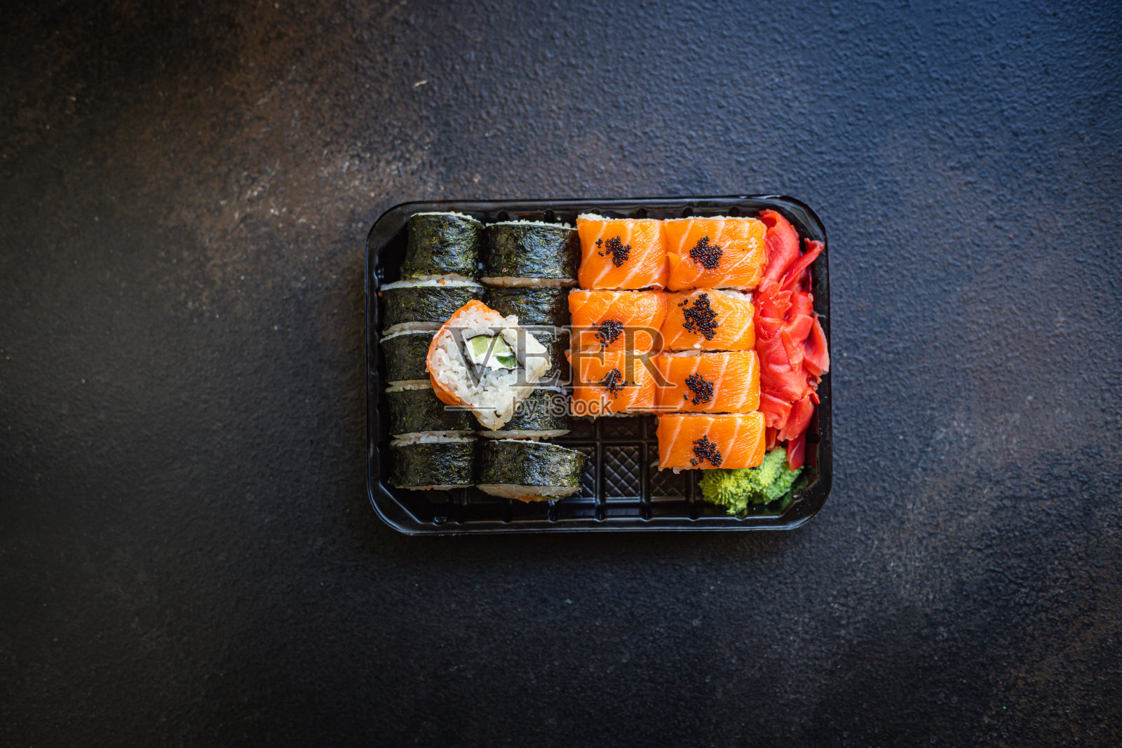 新鲜的寿司卷，三文鱼，飞鱼籽，蔬菜，生姜，芥末，米饭和海苔，上桌大小，俯视图位置，复制空间，文字，食物背景，质朴照片摄影图片