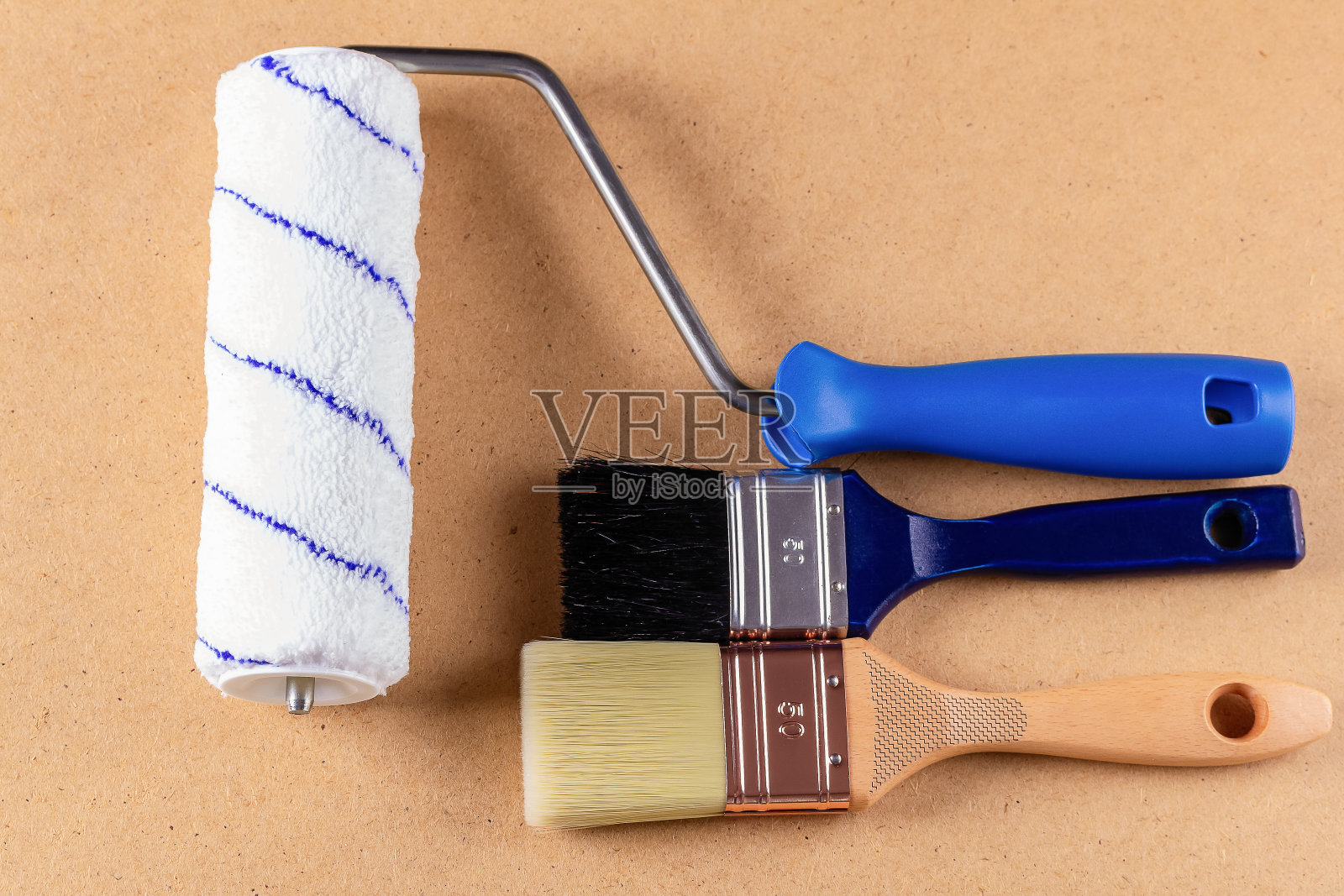 木柄刷子和油漆滚筒在纤维板上。副本的空间。俯视图照片摄影图片