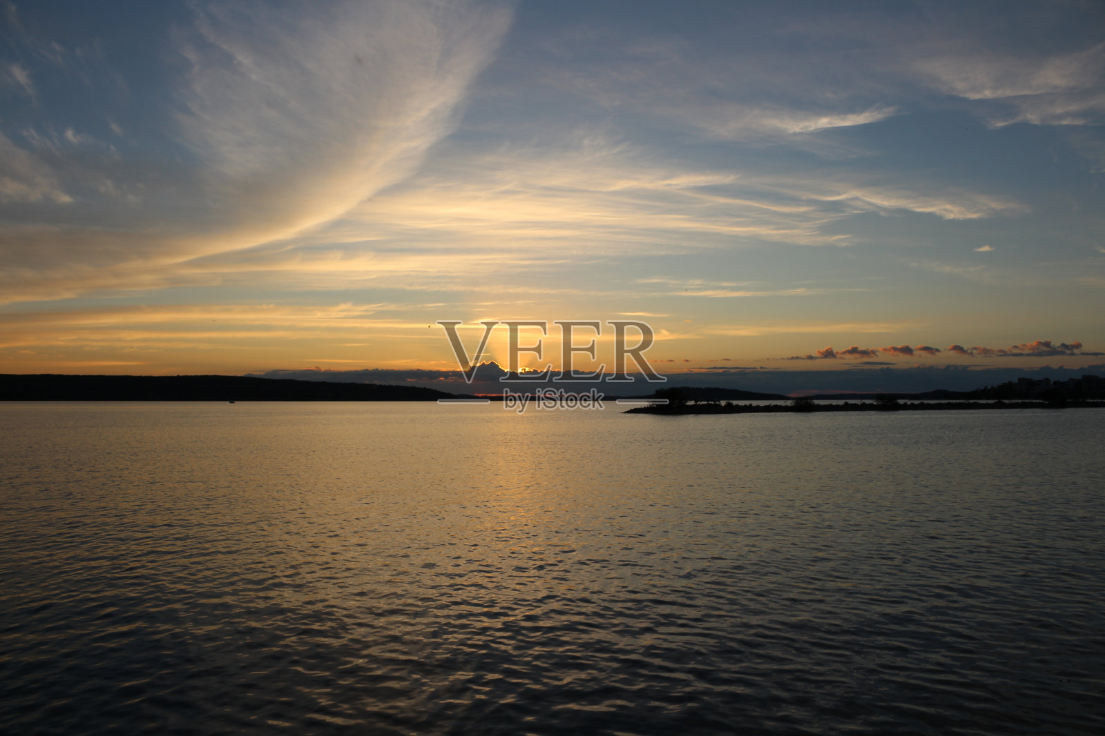 太阳落山的云彩，蓝色的天空与卷云和湖Vesijärvi。拉赫蒂。芬兰。照片摄影图片