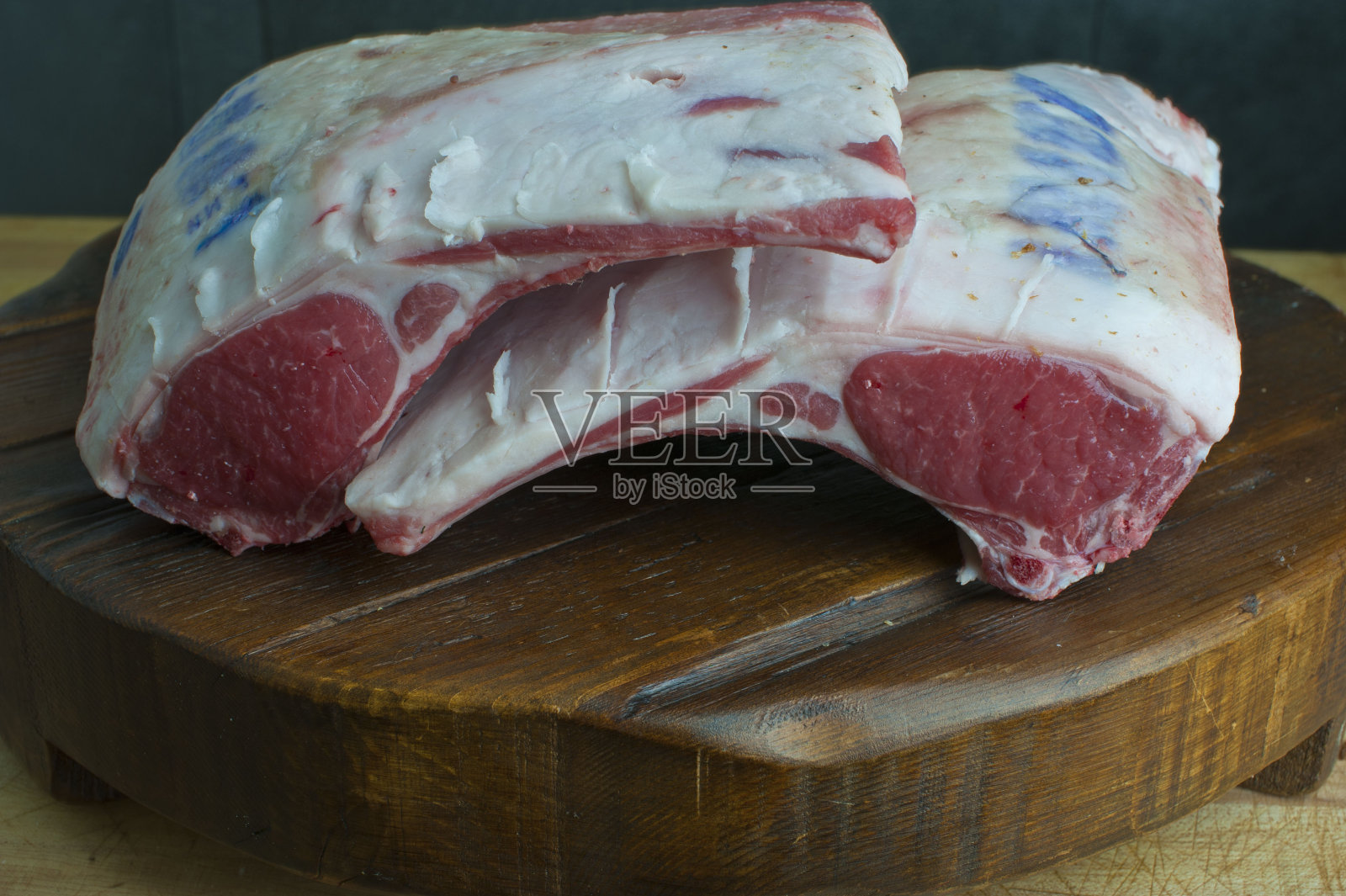 猪排。屠夫商店的生肉拍摄在木制屠夫块。经典的美国肉店切肉。牛排，牛排骨，菲力牛排，猪排骨，猪腰肉，肋眼和羊腿。照片摄影图片