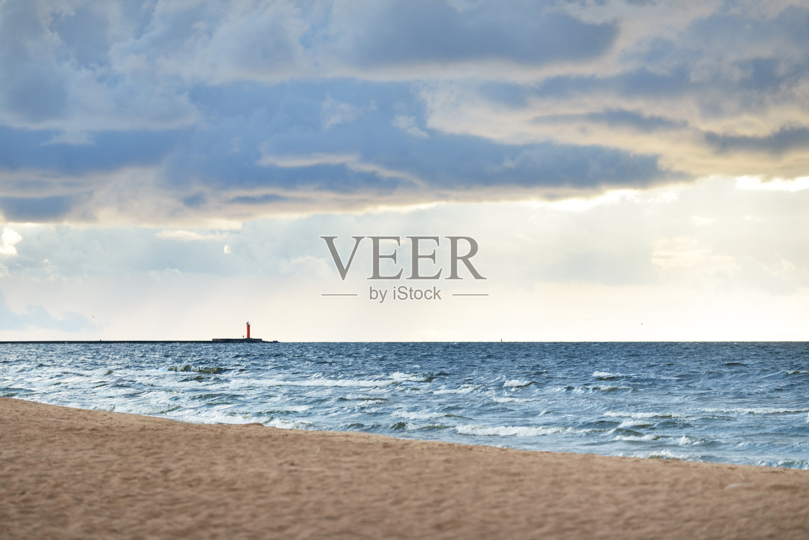 晴朗的天空和许多发光的积云上方的波罗的海海岸后雷雨在日落。背景是灯塔。戏剧性的cloudscape。风景如画的风景。变化无常的天气照片摄影图片