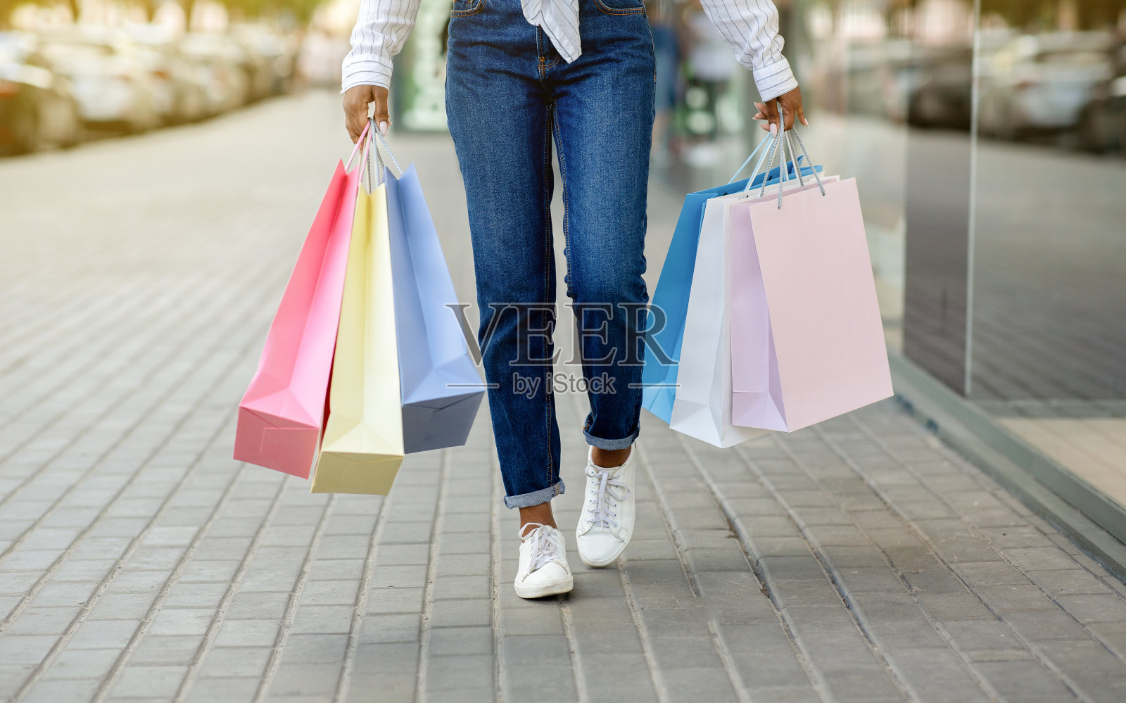 购物狂走。非洲裔美国女孩带着许多彩色的包从商店走出来照片摄影图片