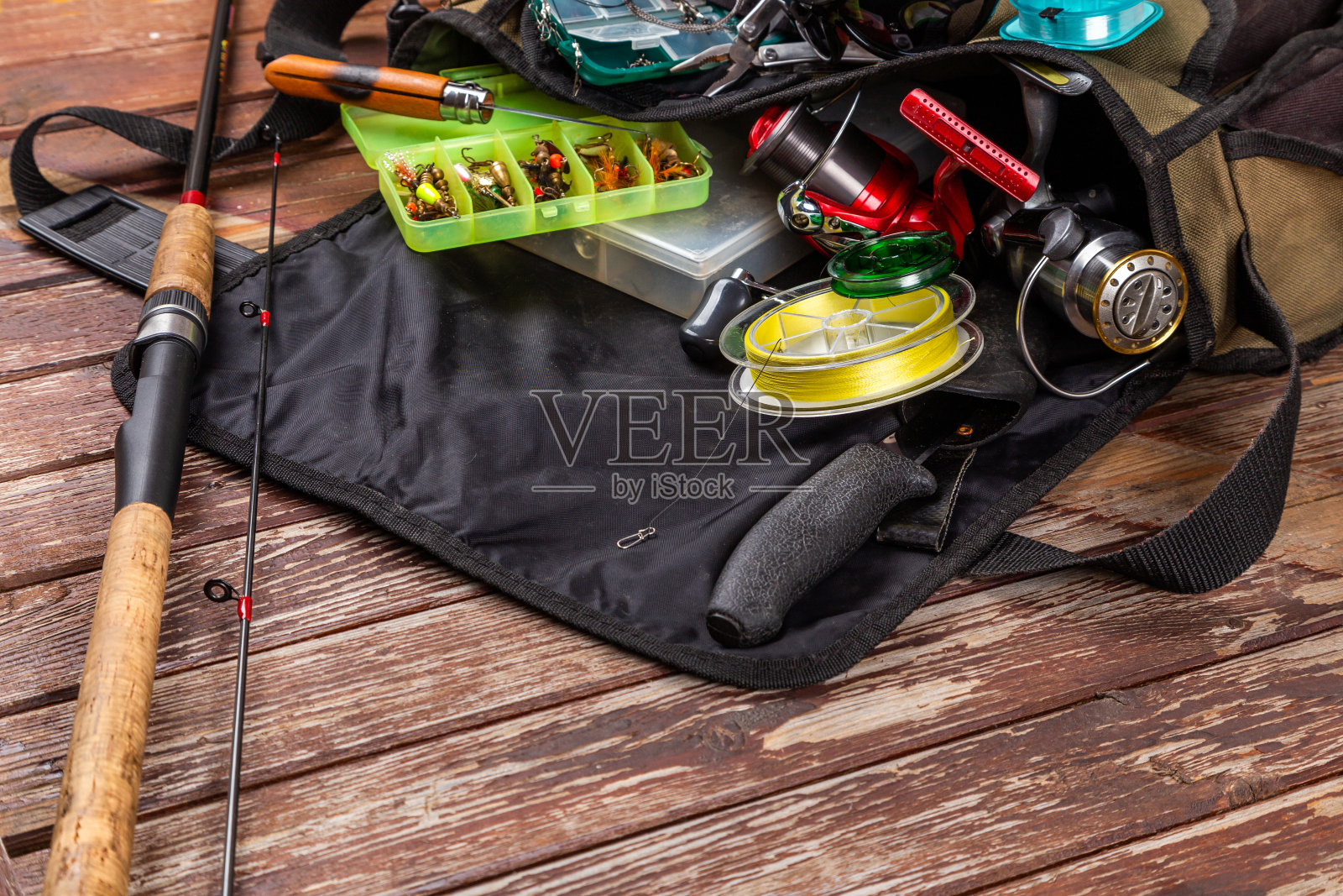不同的钓具与杆和卷轴在木棕色的背景。广告和出版Mockap。照片摄影图片