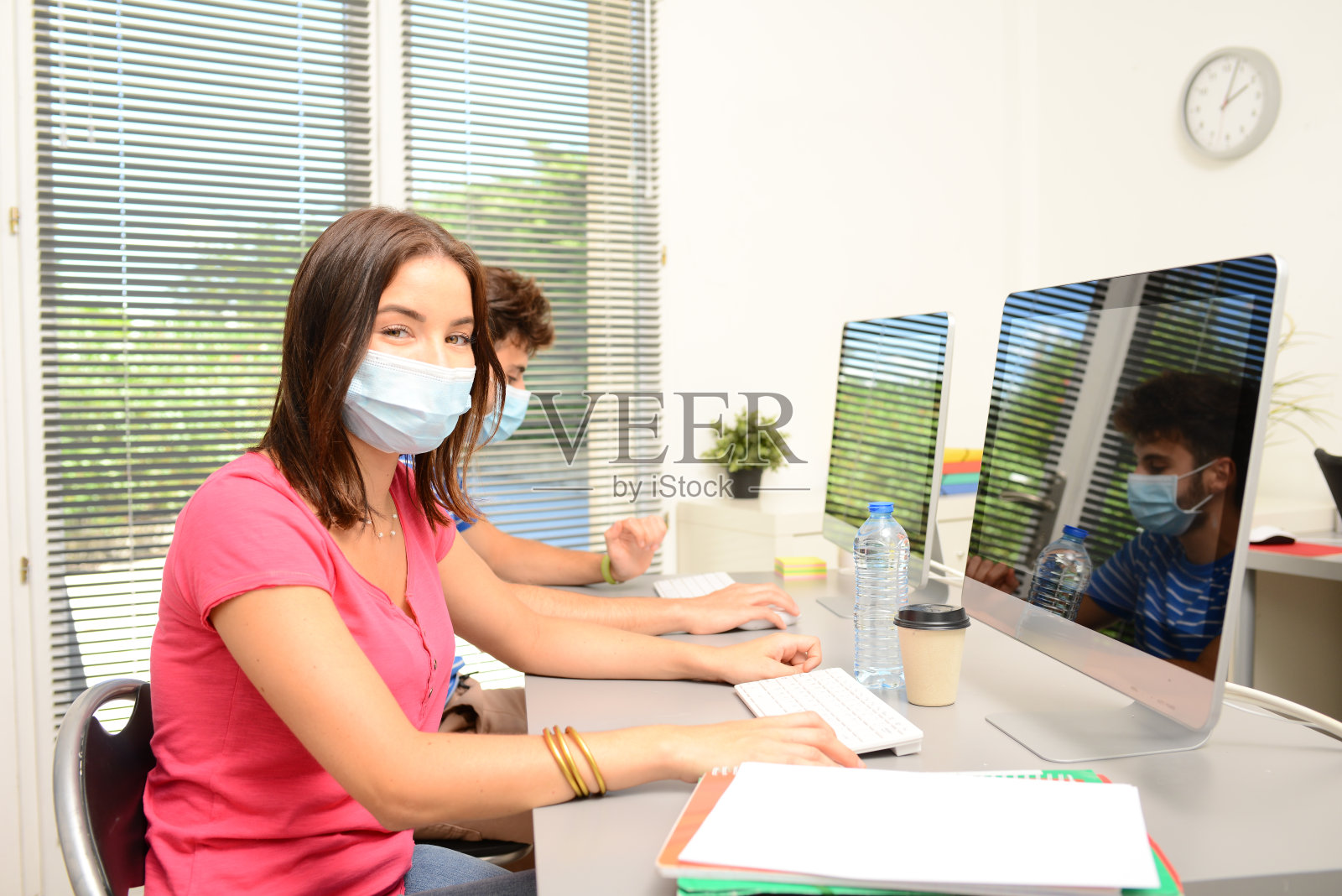 美丽的年轻女孩学生在学校教室里戴着covid - 19外科口罩保护照片摄影图片