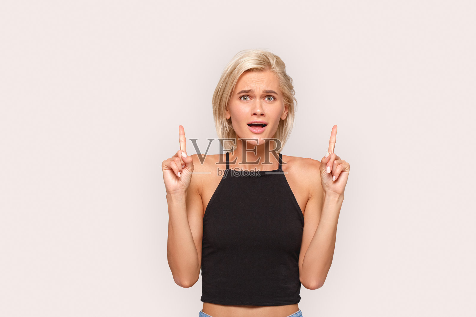 自由泳。年轻的金发女子在上面孤立地站在白色指着副本空间兴奋地微笑照片摄影图片