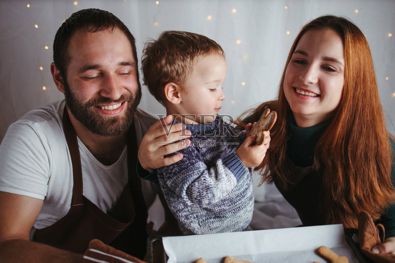 小男孩和拿着姜饼饼干的父母照片摄影图片