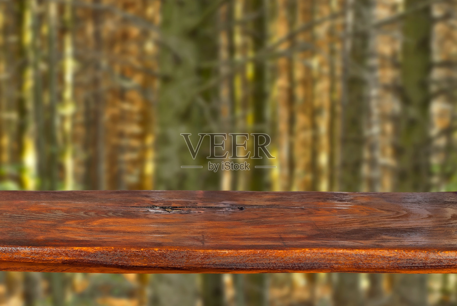 以针叶林为背景的旧木板。在模糊的树干背景上清晰的木板表面。设计的模型。复制产品广告空间。照片摄影图片