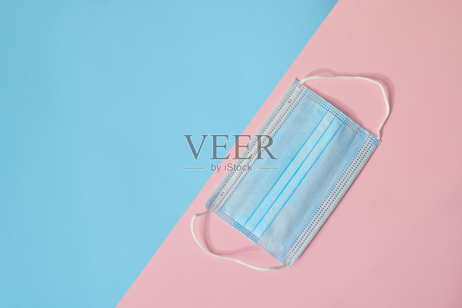 医用防护口罩，粉色和蓝色背景照片摄影图片
