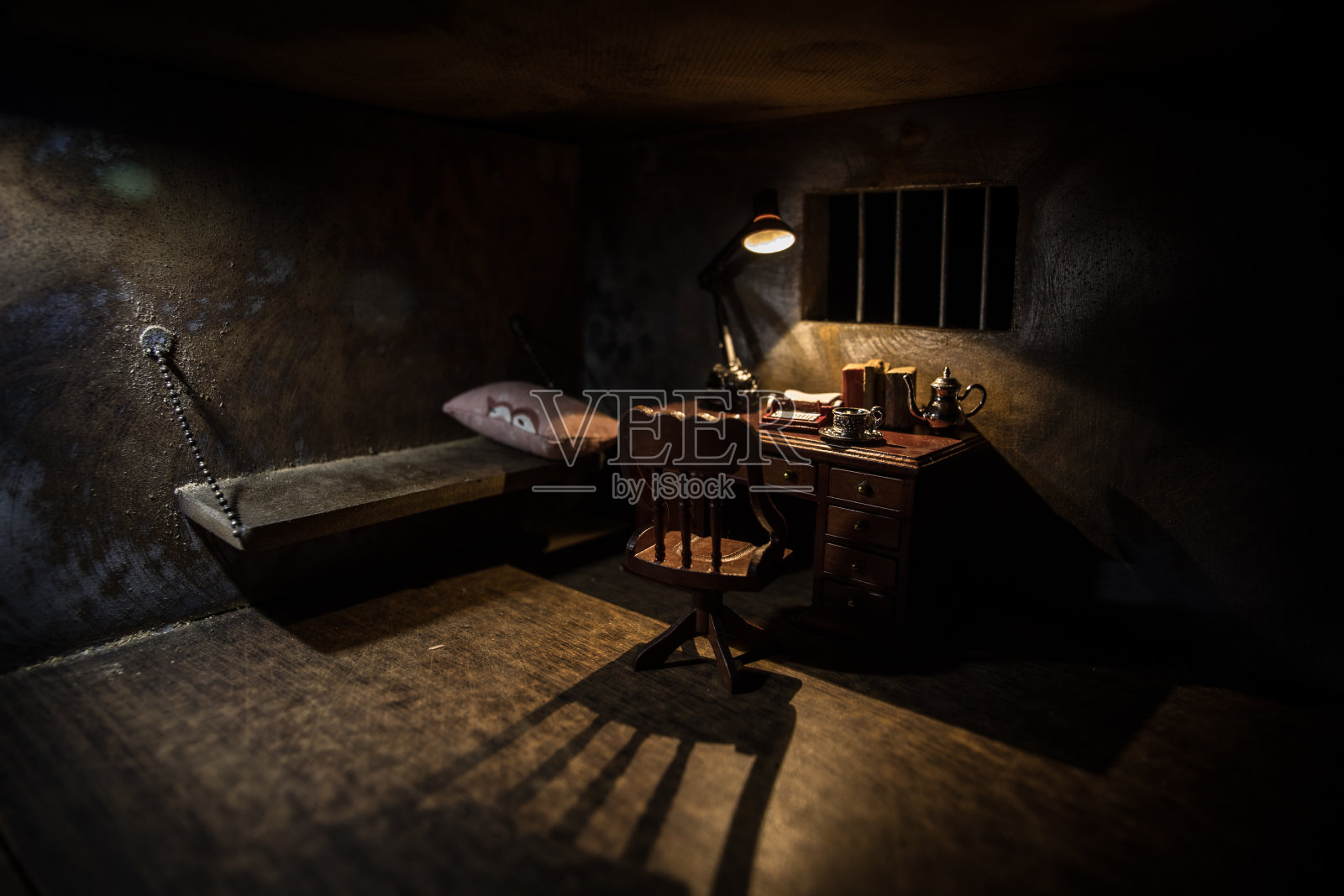 监狱或牢房。男人在监狱里，男人在监狱里。又老又脏的监狱迷你版。黑暗监狱内部创意装修。有选择性的重点照片摄影图片