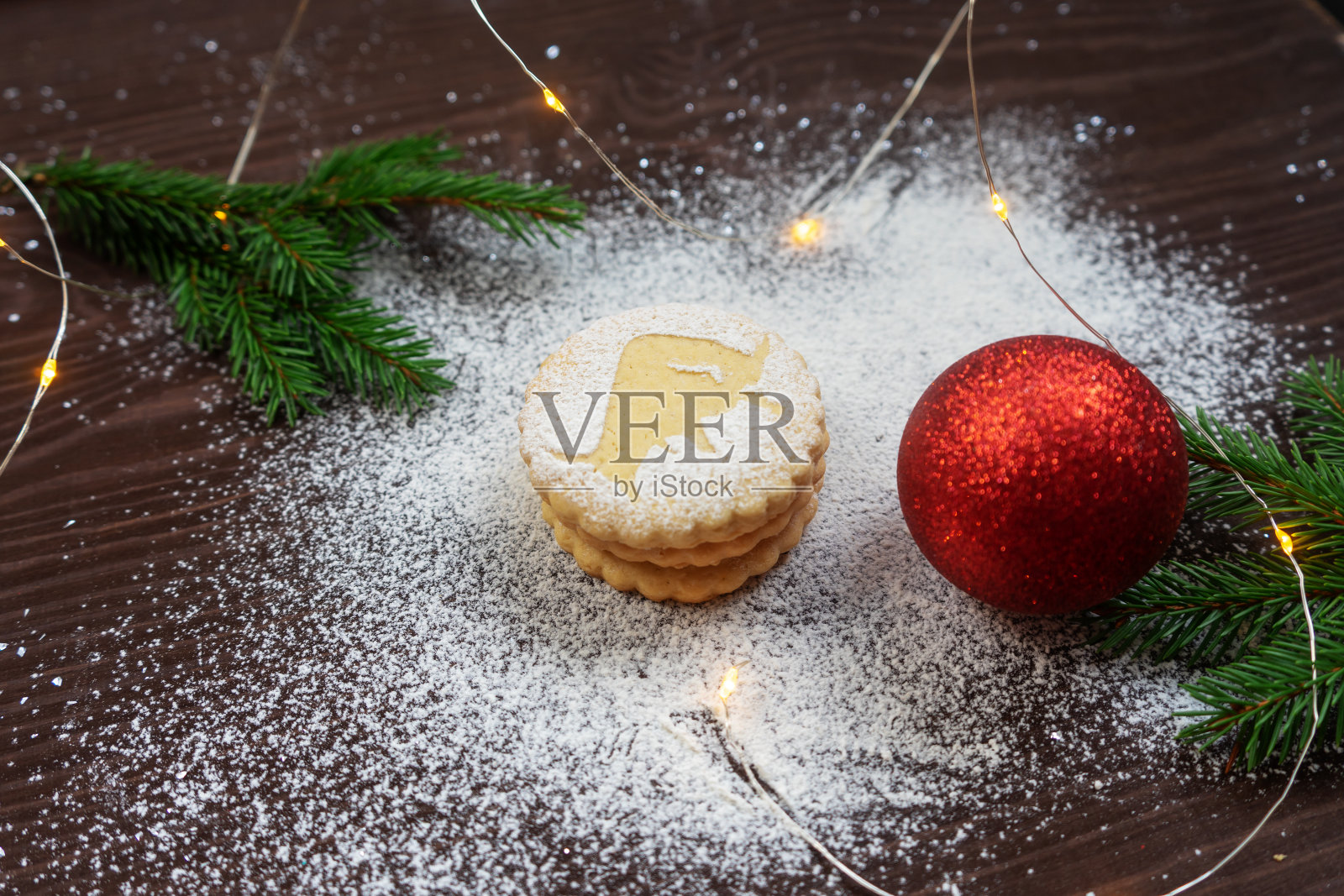 用饼干、云杉树枝和装饰品装饰的圣诞节日布局。脆饼与公牛的剪影特写。照片摄影图片