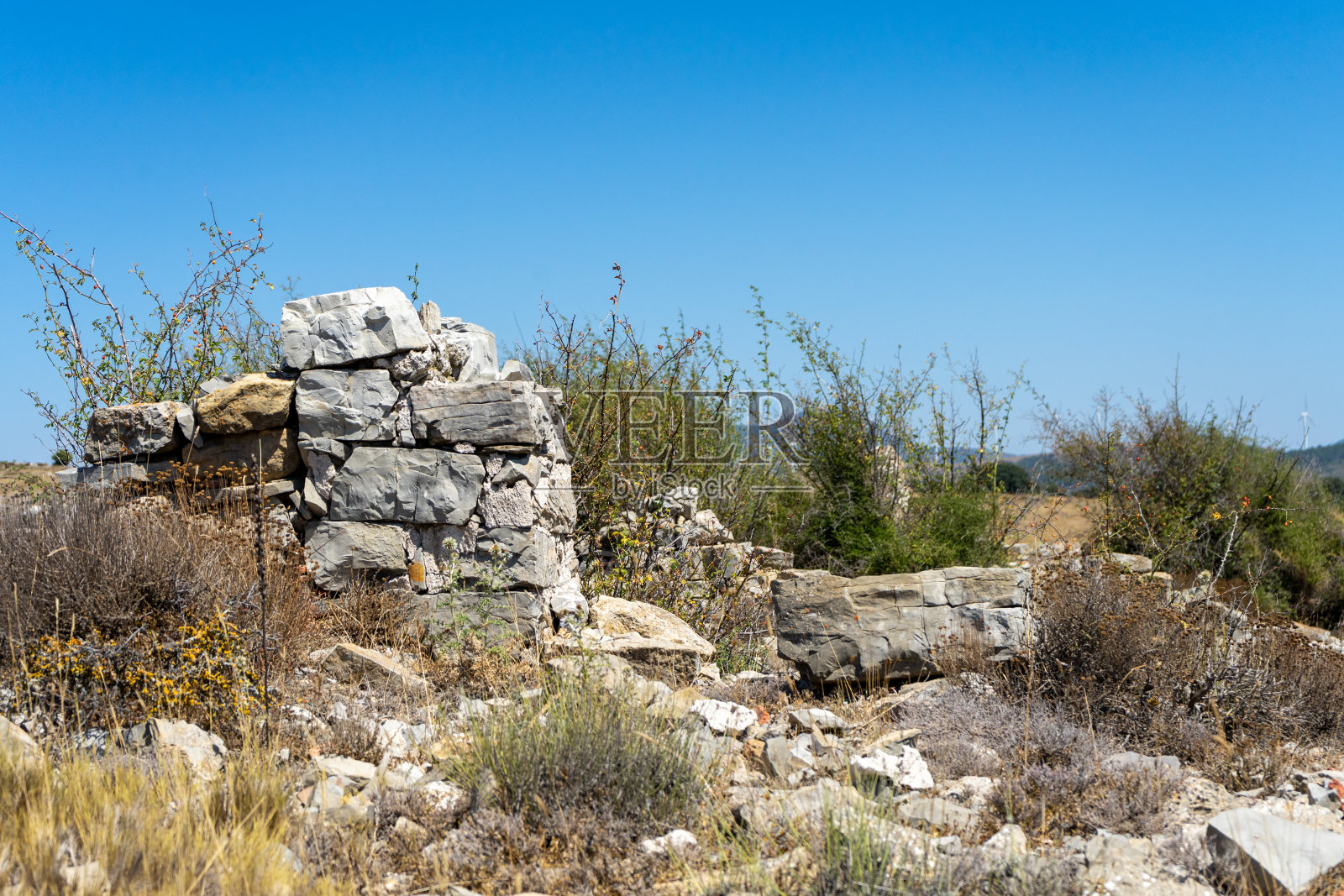 山上有一座由灰色石块砌成的房子的古老废墟照片摄影图片