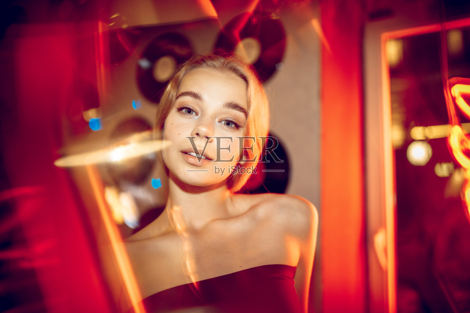 电影肖像的英俊的年轻女子在霓虹灯的房间，时尚的音乐家照片摄影图片