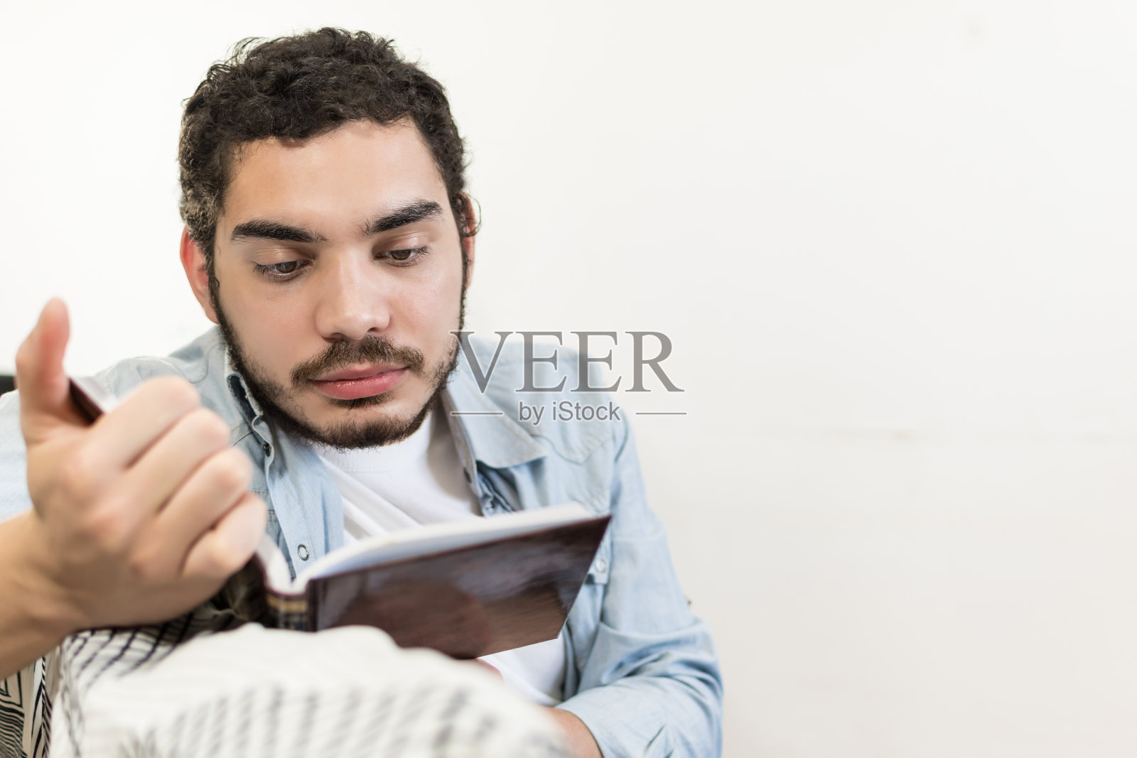 正在看书的严肃络腮胡年轻男人照片摄影图片