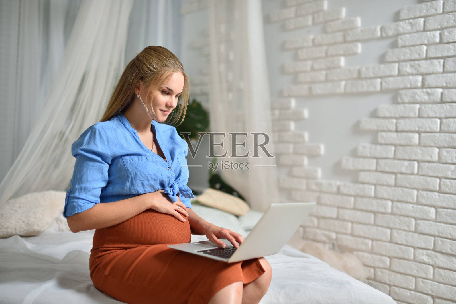 一个20岁的年轻孕妇家里有一台笔记本电脑照片摄影图片