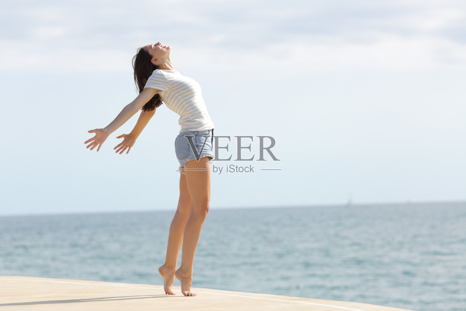 长腿的兴奋女人呼吸着新鲜空气照片摄影图片