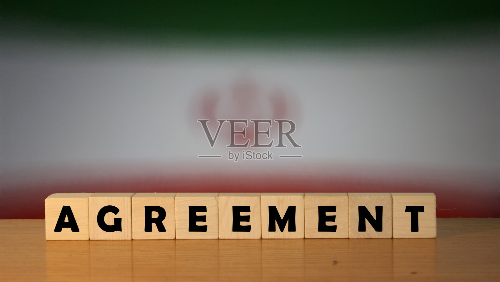 以伊朗国旗为背景的立方体木桌上写着协议信息照片摄影图片