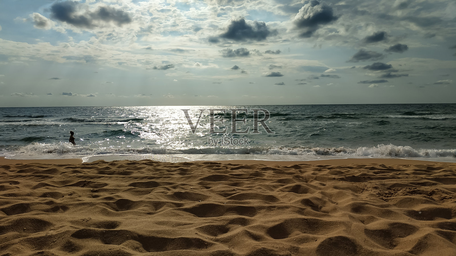 一个孤独的保加利亚海滩和平静的大海在早晨的阳光破云。照片摄影图片