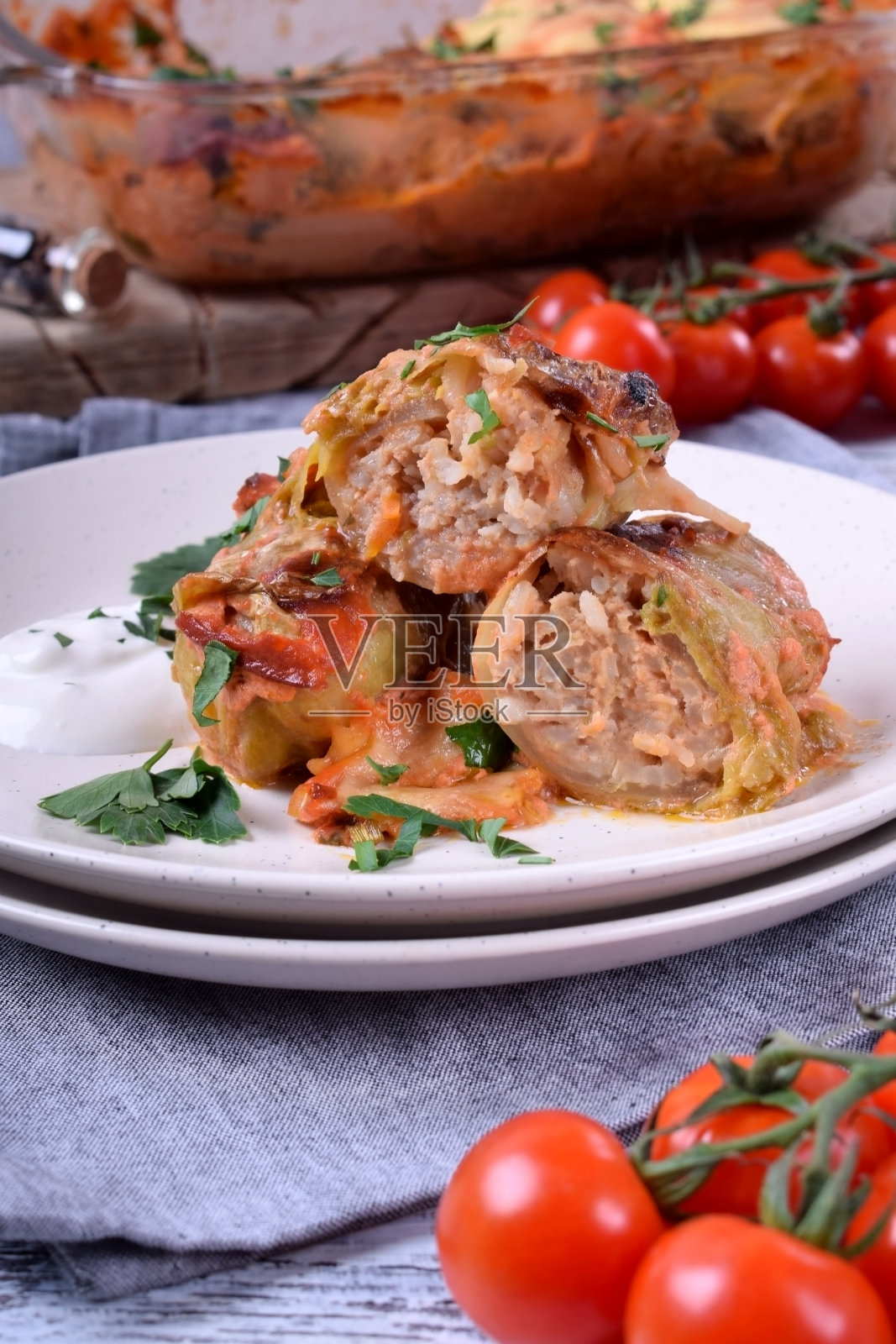 烤白菜卷配肉，盛在白盘子里照片摄影图片