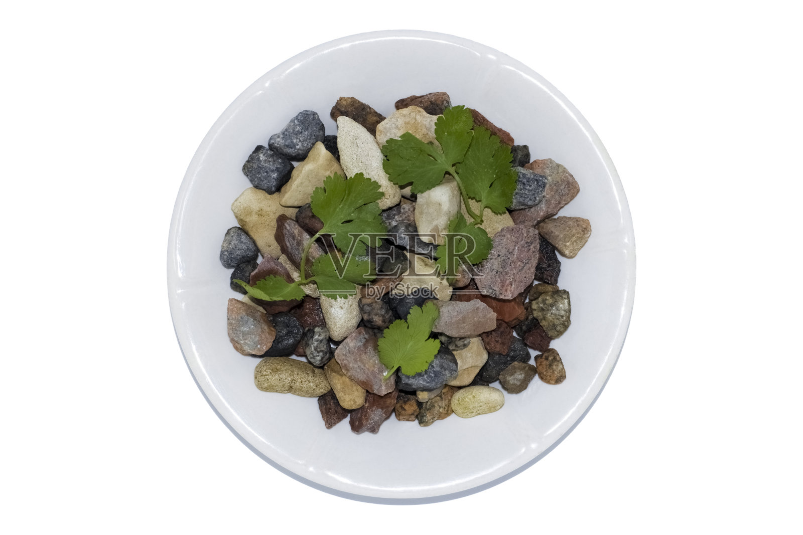 五颜六色的花岗岩放在一个白色的盘子里，背景是白色的香菜花瓣照片摄影图片