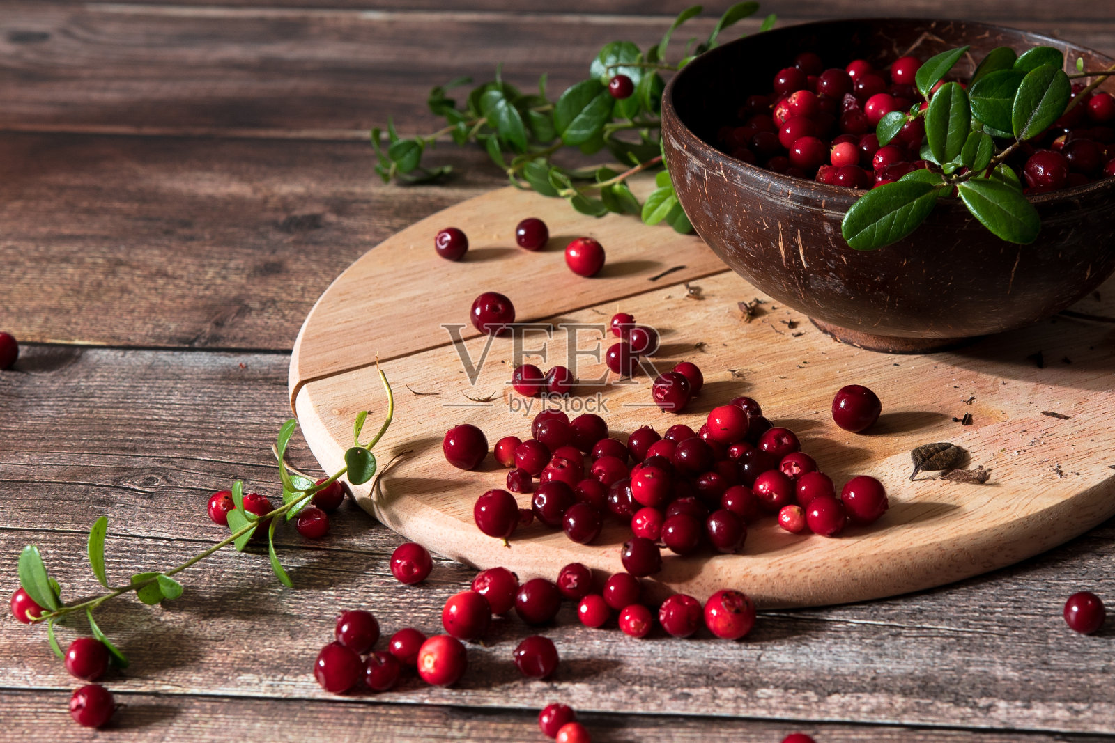 木背景上的碗里装着新鲜的蔓越莓照片摄影图片