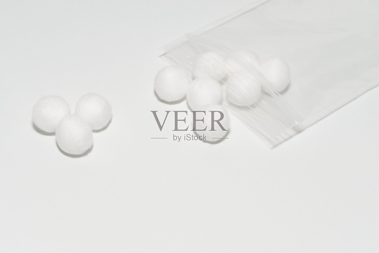 白色棉球和透明塑料袋。照片摄影图片