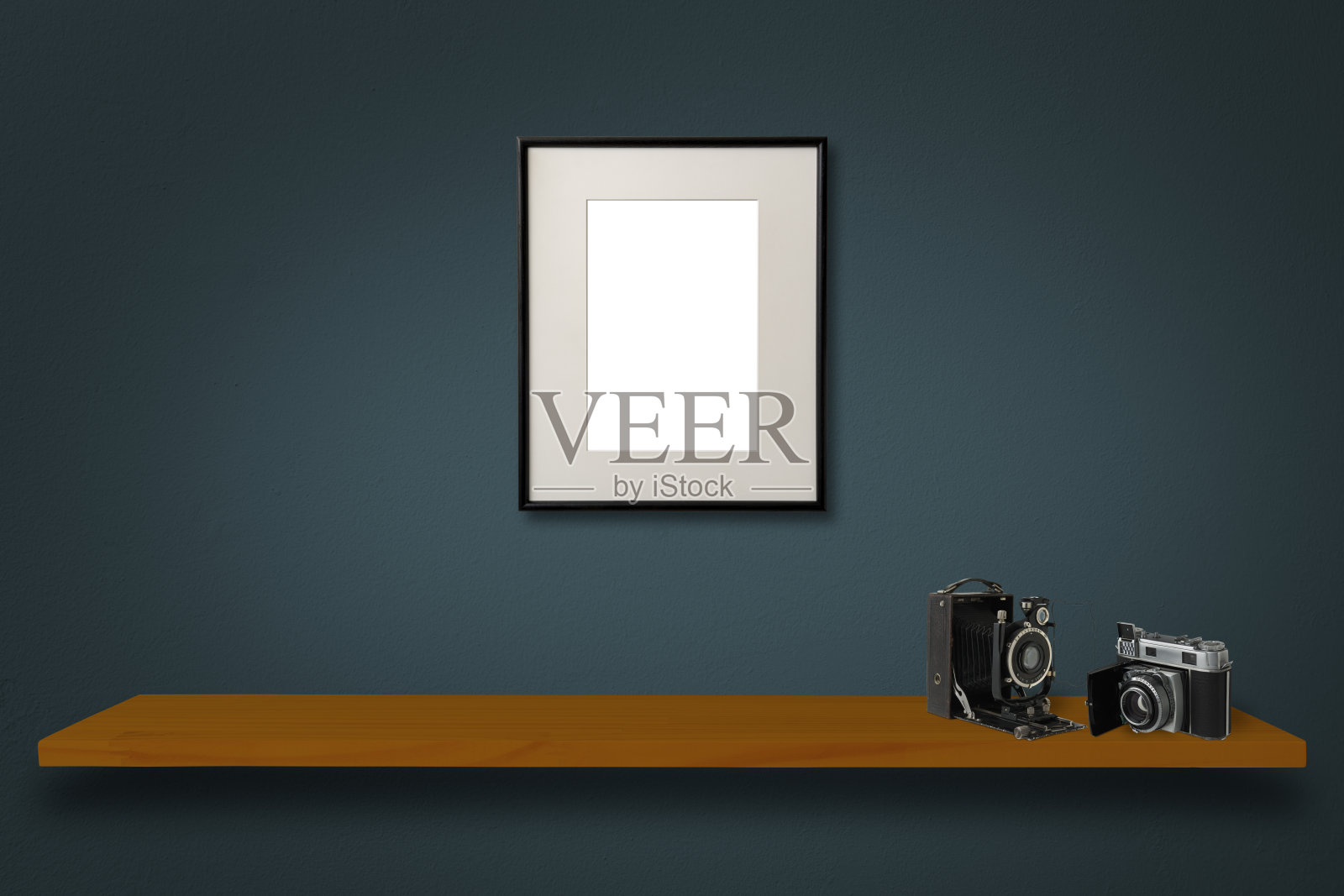 墨绿色墙壁上的空白木制画框。照片摄影图片