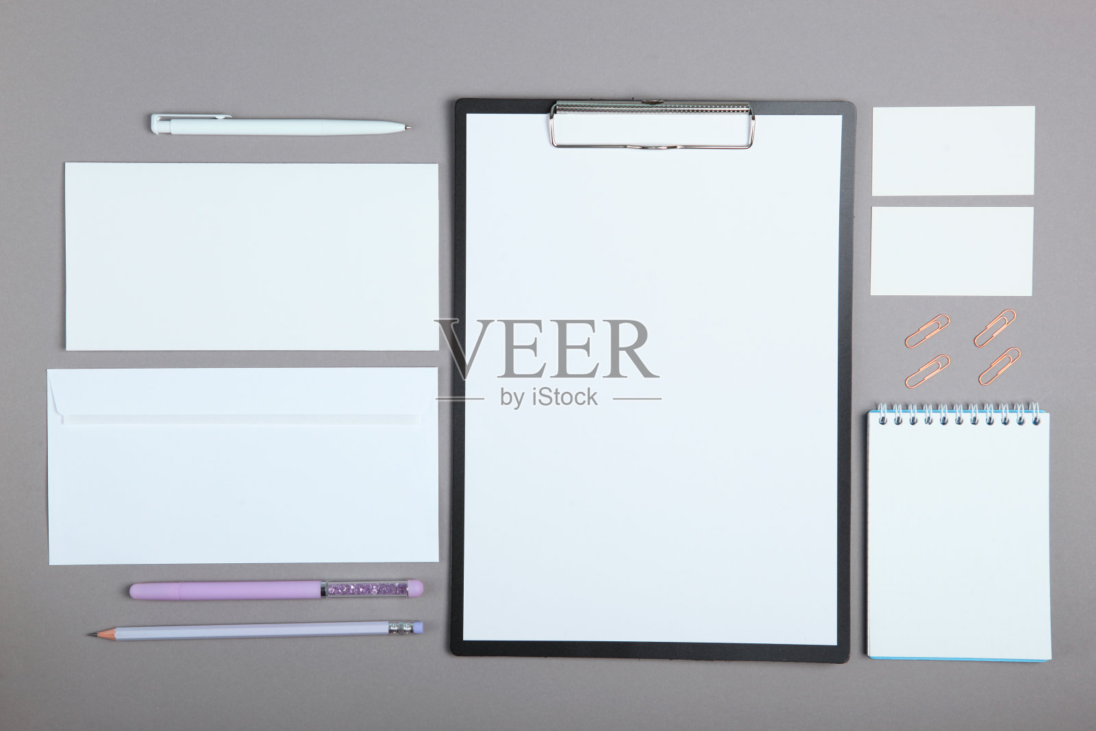 白色的文具品牌，舞台布局在一个柔和的彩色背景上，空的物体适应您的设计，倾斜。照片摄影图片