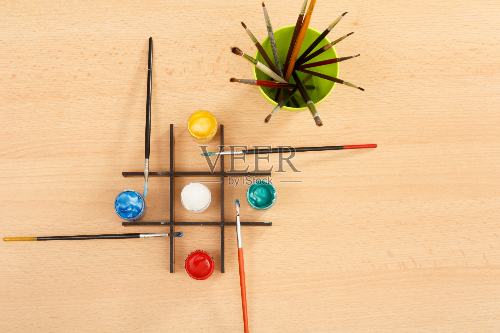 杯子里的颜料和画笔放在木桌上照片摄影图片