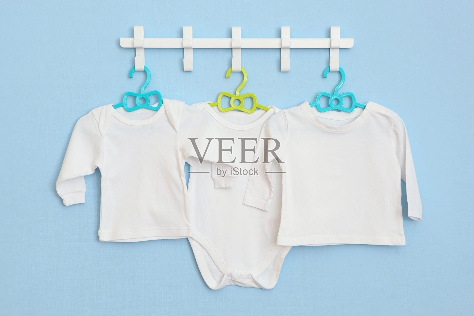 婴儿衣服挂在衣架上。文字的地方，极简主义。照片摄影图片