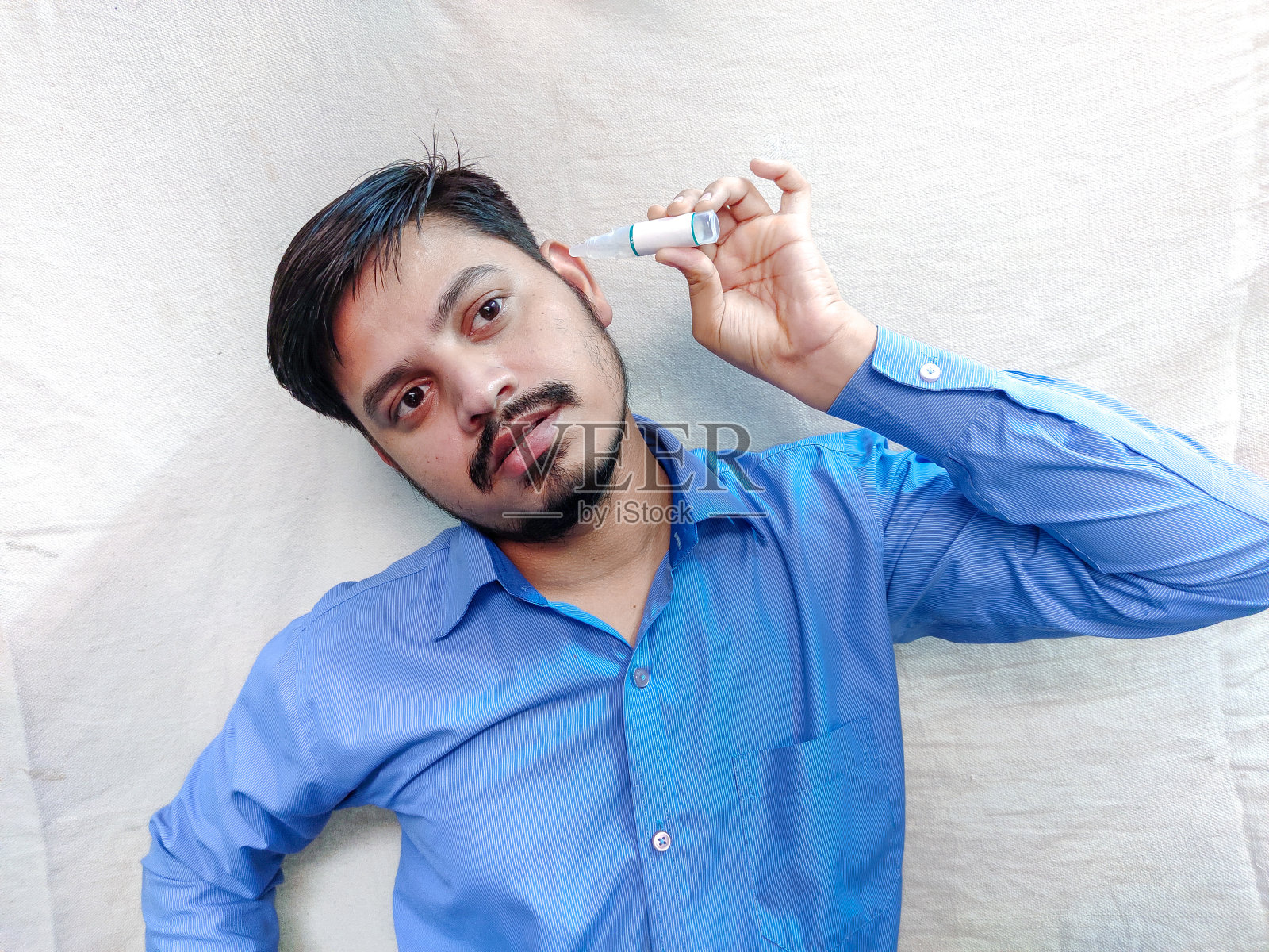 往耳朵里滴耳坠治疗疼痛的人照片摄影图片