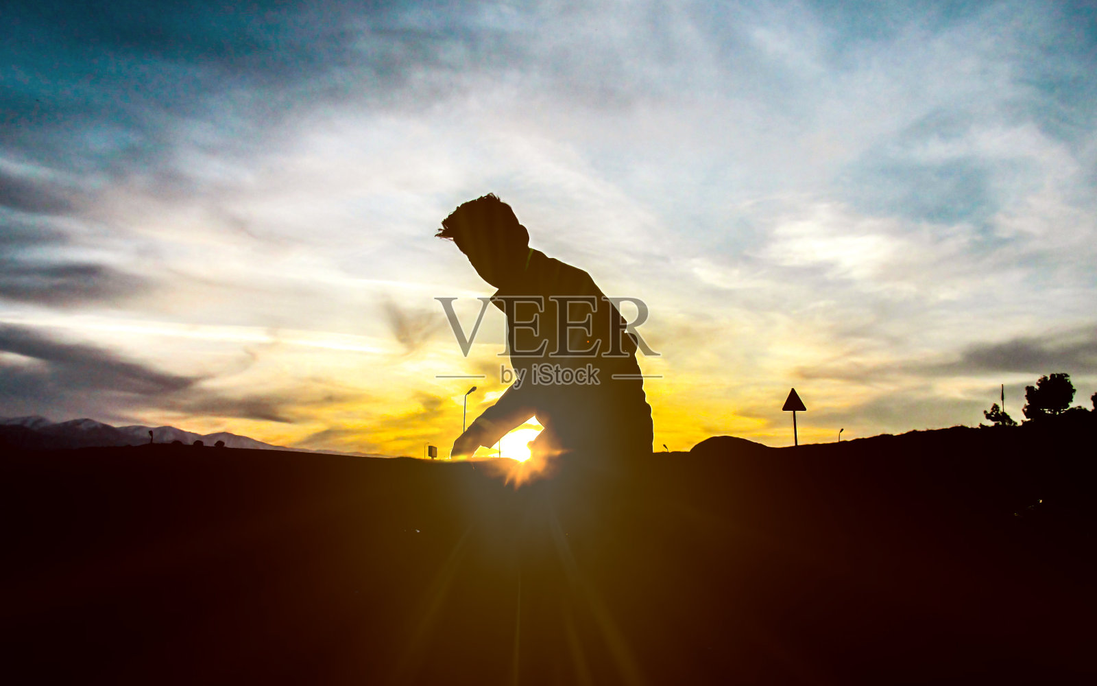 在夕阳下搭起帐篷的年轻人。照片摄影图片