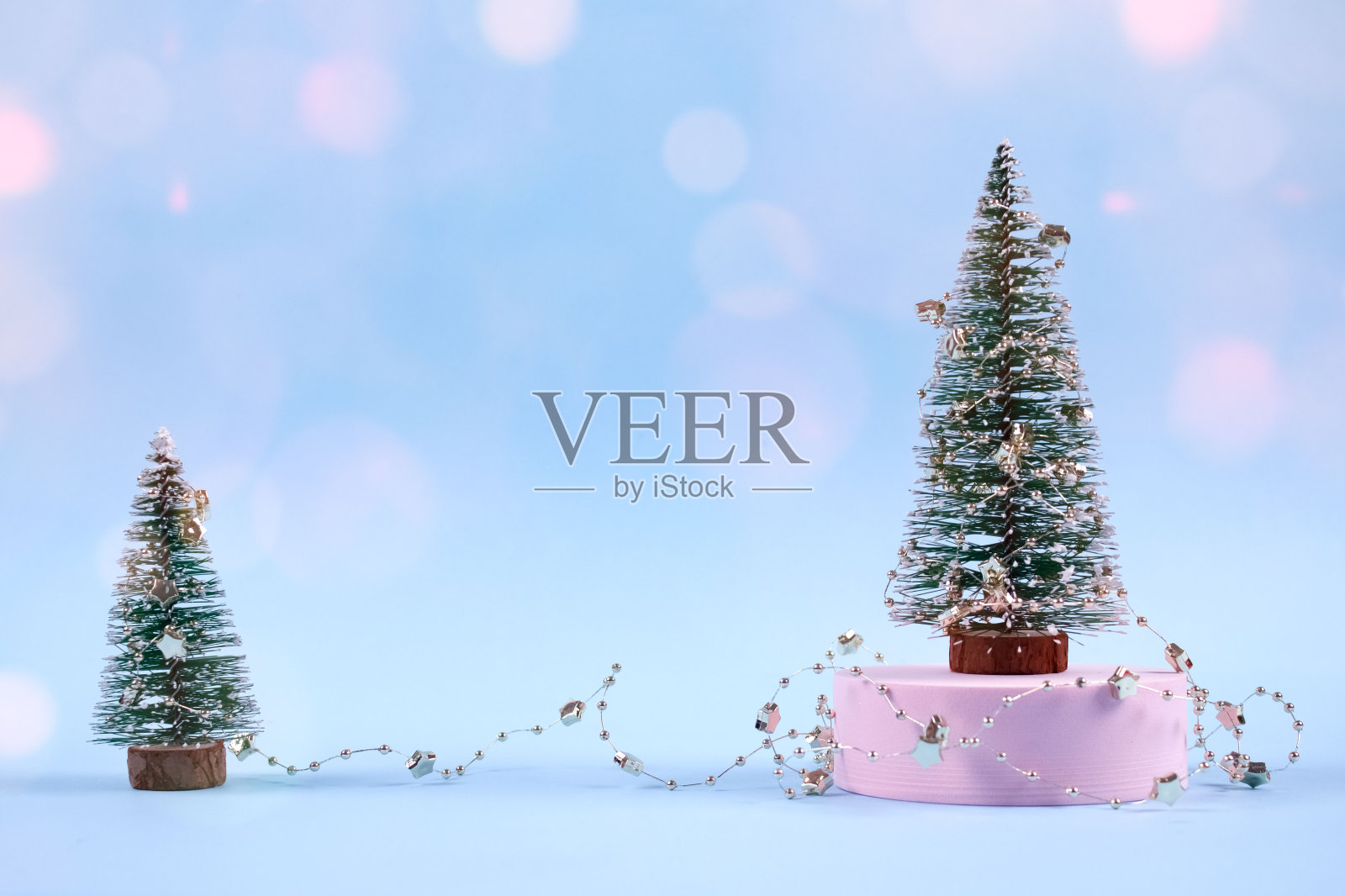 圣诞树或新年树与圣诞装饰和粉红色的散景灯在时尚的蓝色背景与copyspace为您的文本。选择焦点，放置文本照片摄影图片