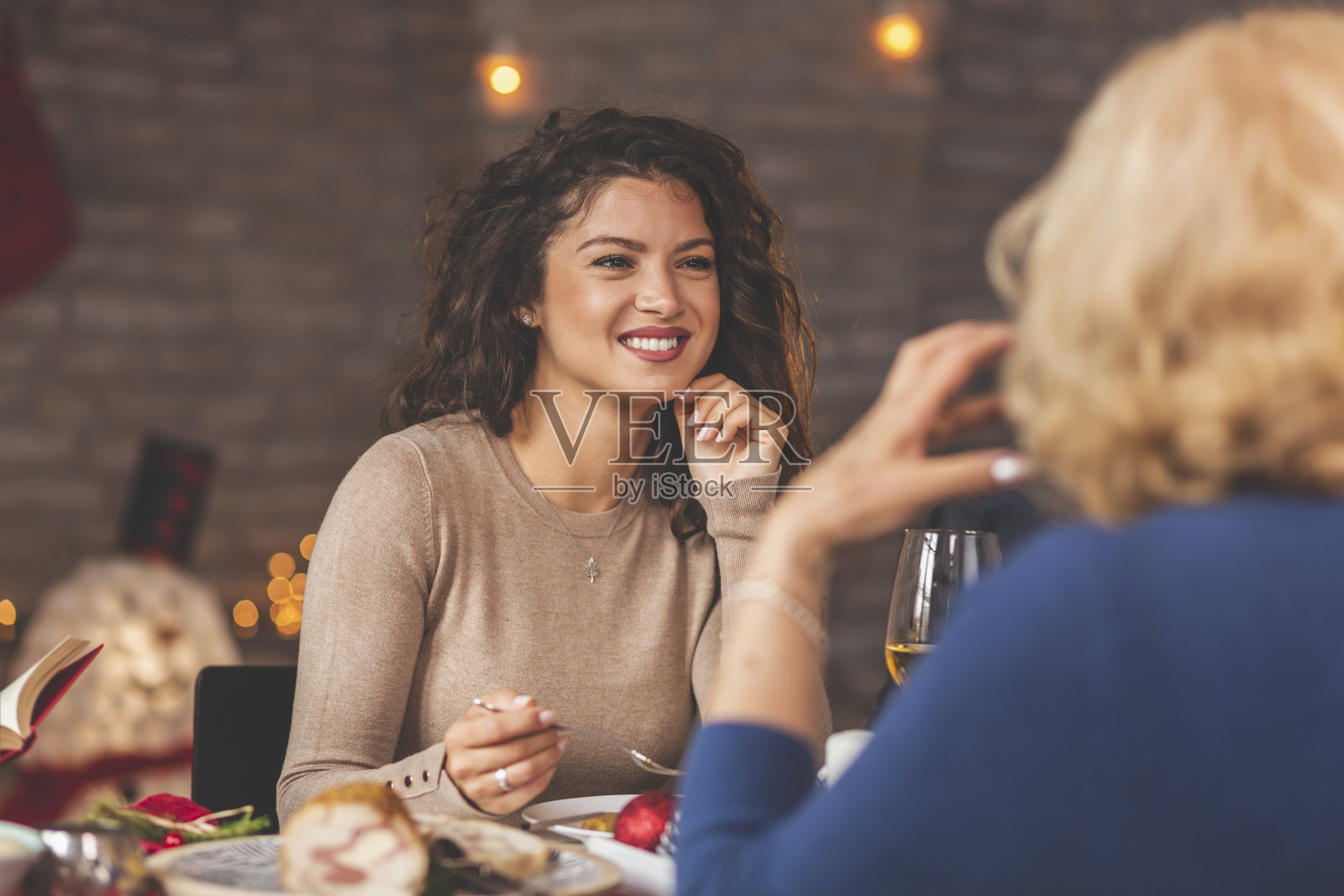 母亲和女儿在圣诞晚餐上交谈照片摄影图片