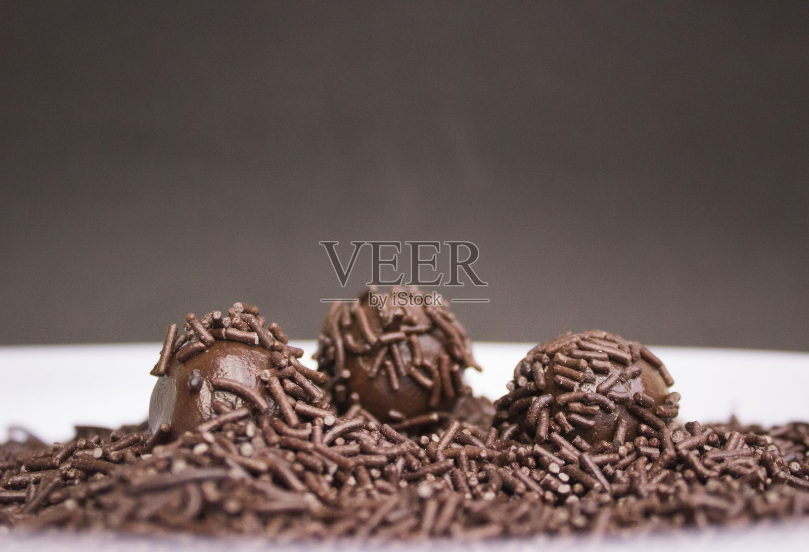 倒入巧克力颗粒。自制的巴西糖果。Brigadeiro，葡萄牙语里的"brigadier"巴西传统甜点。照片摄影图片