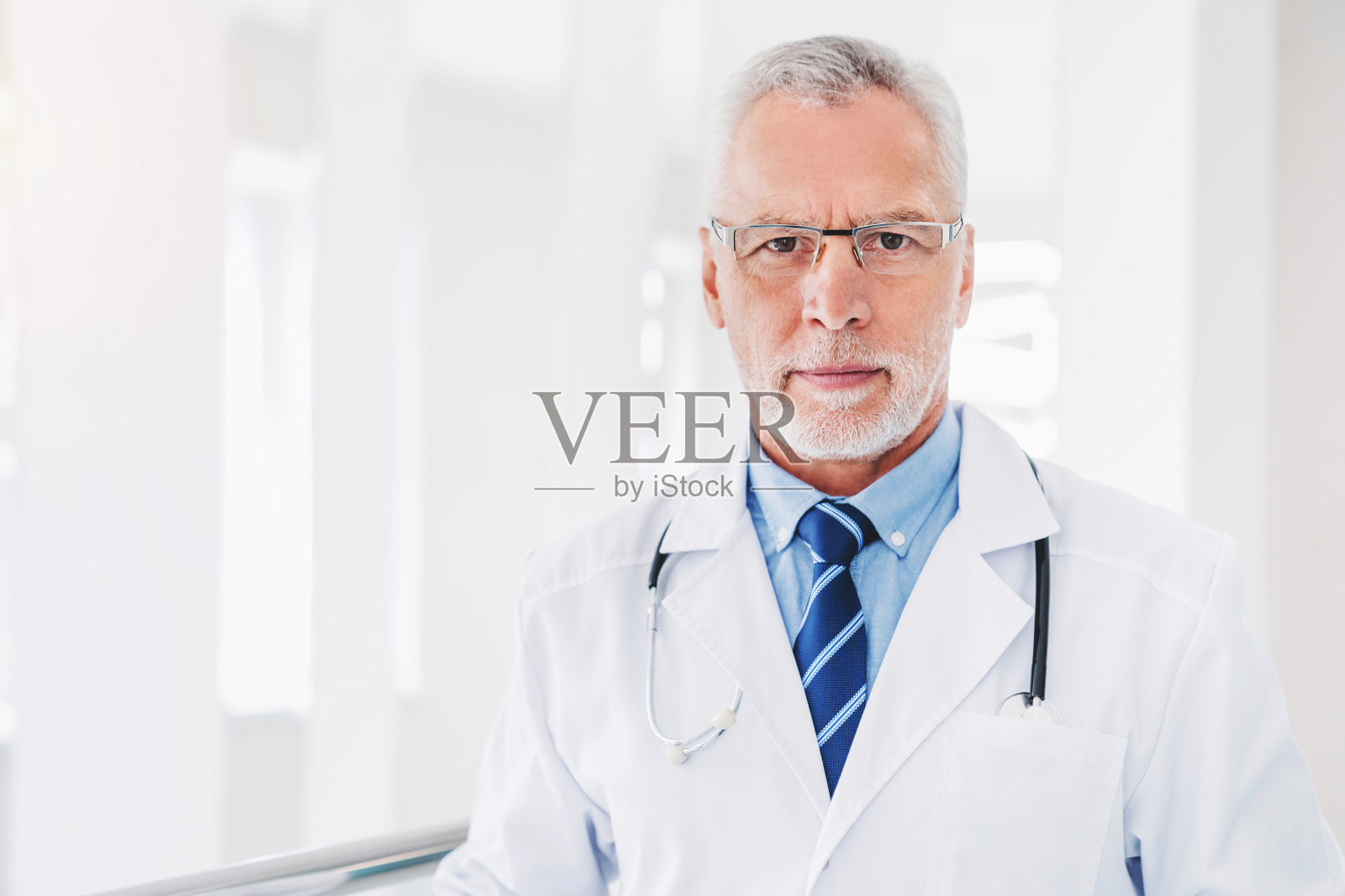 高级医生在医院工作时站在大厅里的肖像照片摄影图片