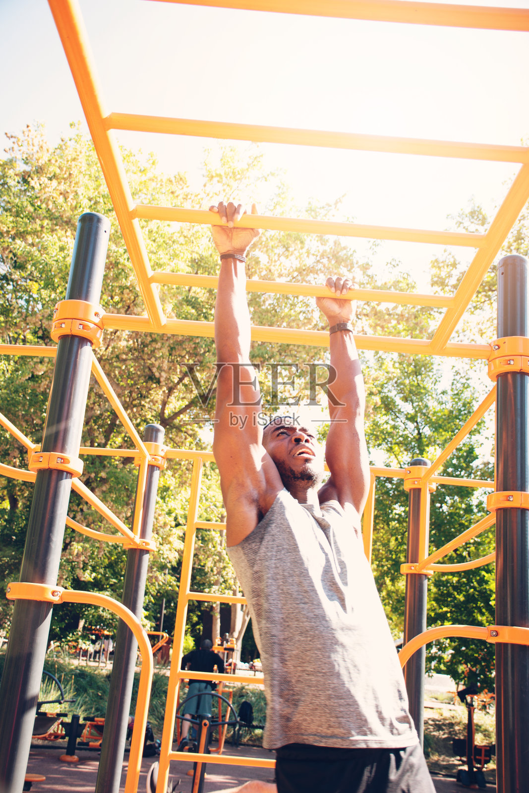 英俊的非裔美国年轻人做引体向上在户外健身酒吧照片摄影图片
