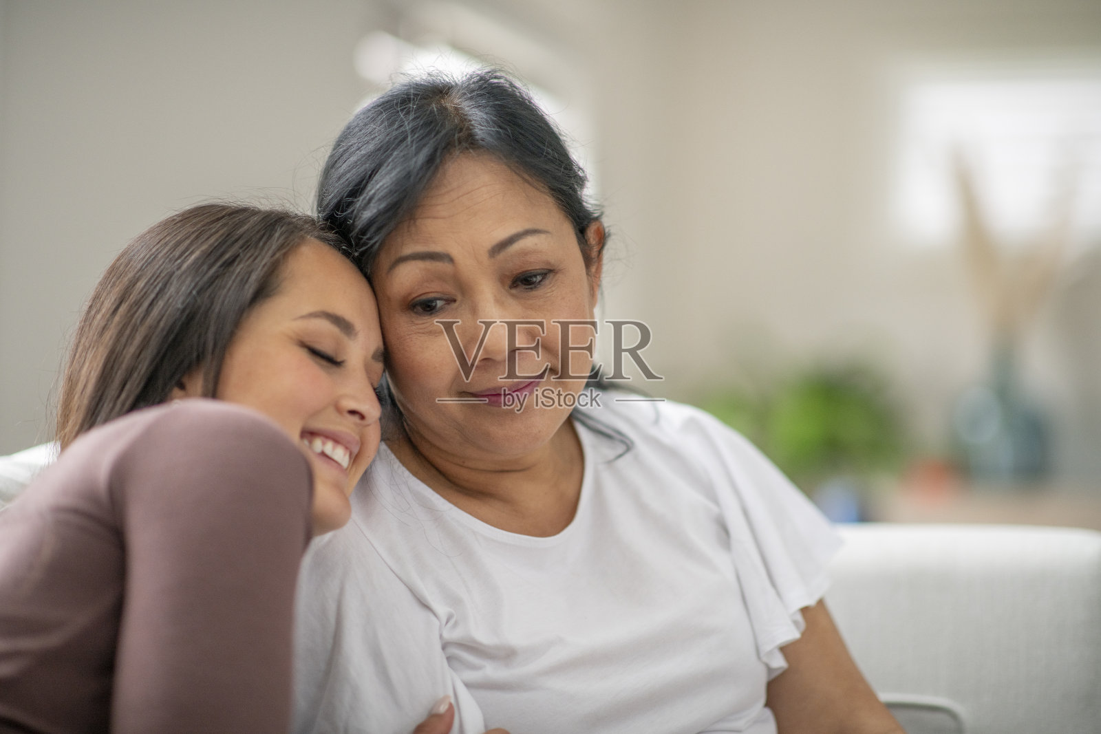 母亲和女儿在家里拥抱照片摄影图片