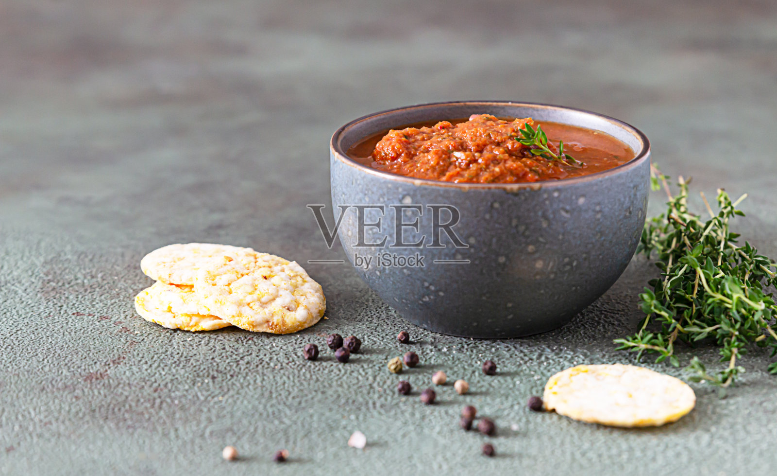 陶瓷碗，香辣番茄酱，玉米片和百里香在绿色的石头背景。墨西哥食物的概念。照片摄影图片