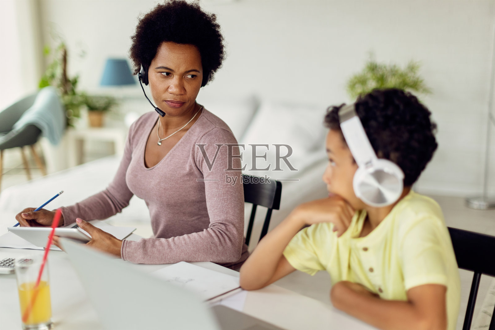 非裔美国母亲在家和儿子聊天。照片摄影图片