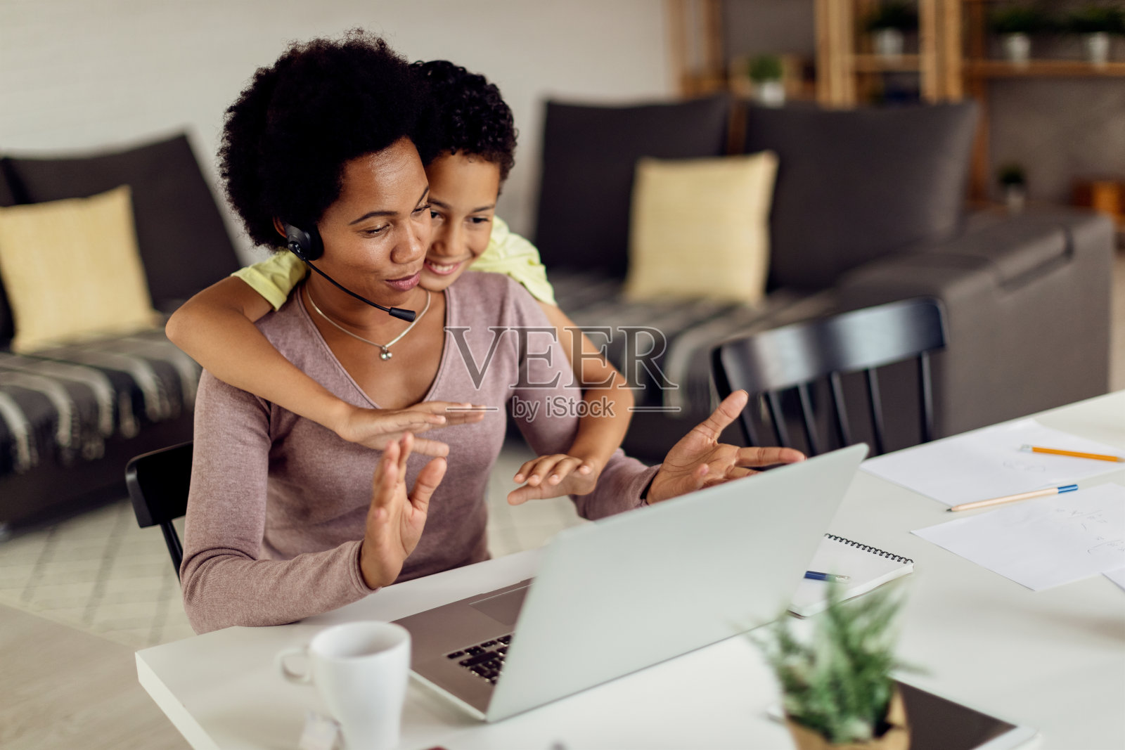 快乐的黑人母亲和儿子在玩的同时，通过家里的电脑进行视频通话。照片摄影图片