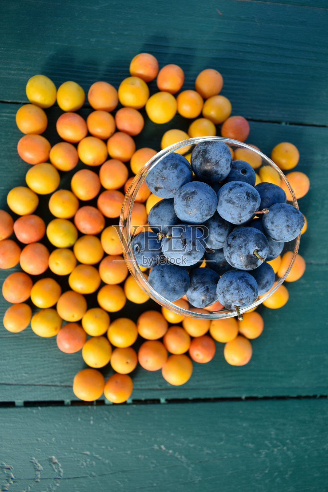 木桌上放着五颜六色的野李子照片摄影图片