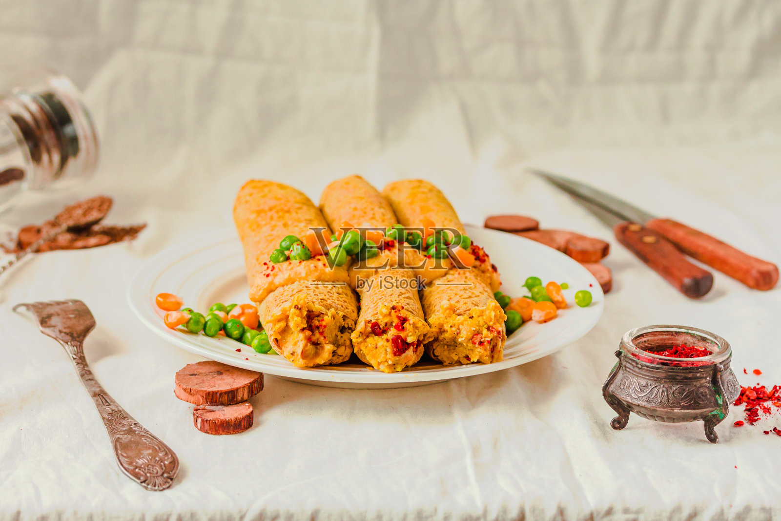 无麸生酮可丽饼在烤箱里填满红辣椒鹰嘴豆泥，上面放咖喱酱、甜玉米和青豆照片摄影图片