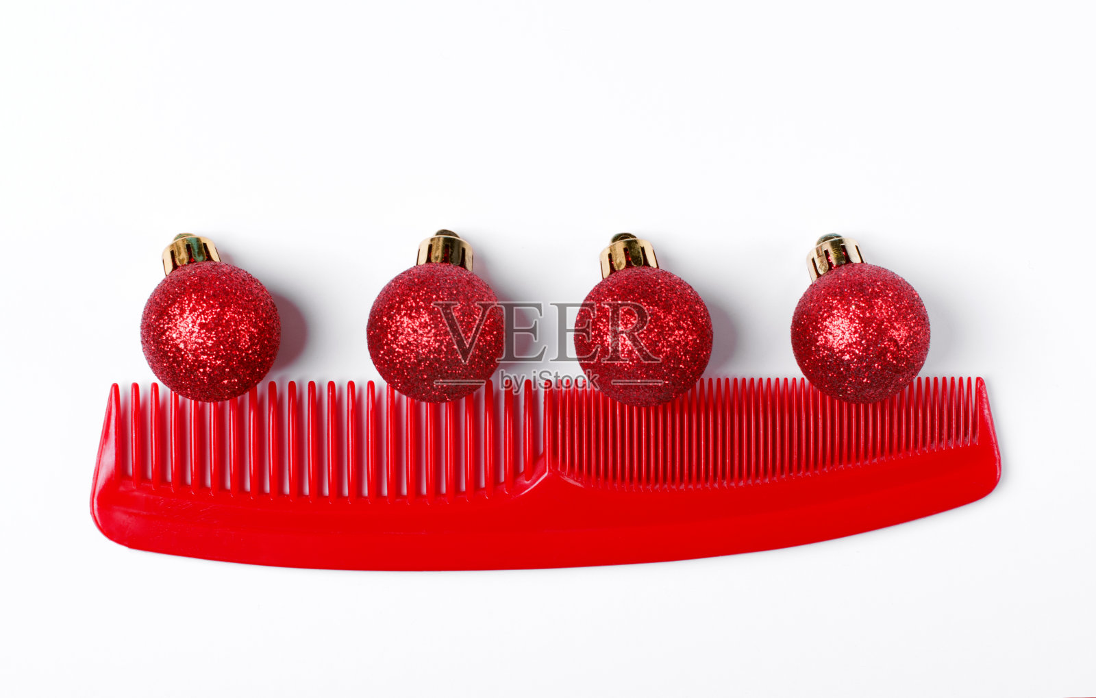 红梳子上的红色小玩意，映衬着白色的背景照片摄影图片