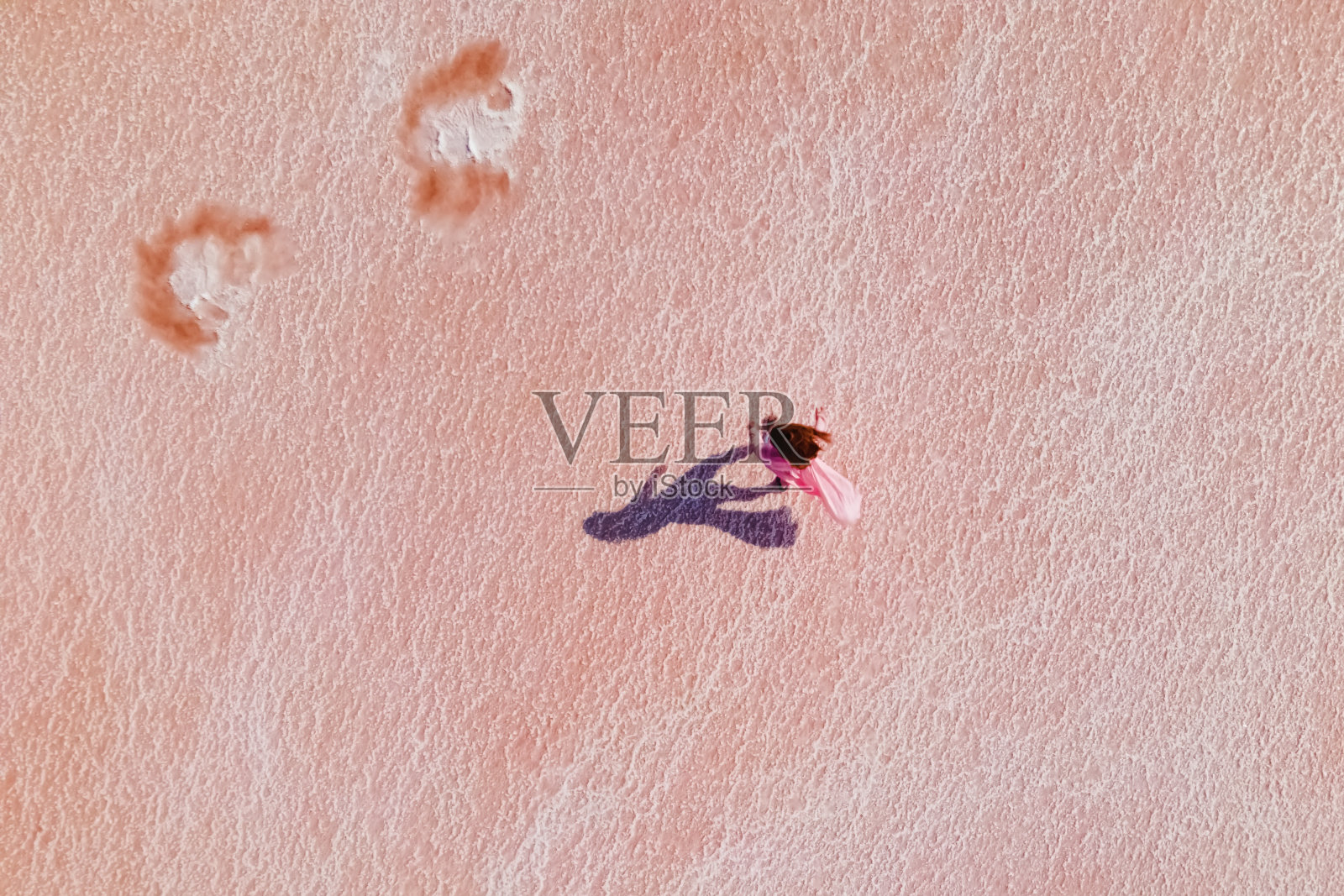 女子行走在亮粉色的生理盐水表面照片摄影图片