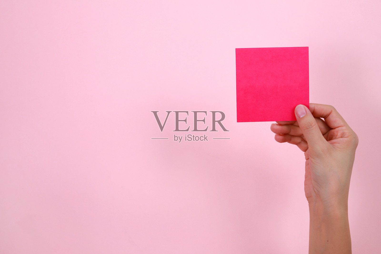 手里拿着一张空白的方形卡片照片摄影图片