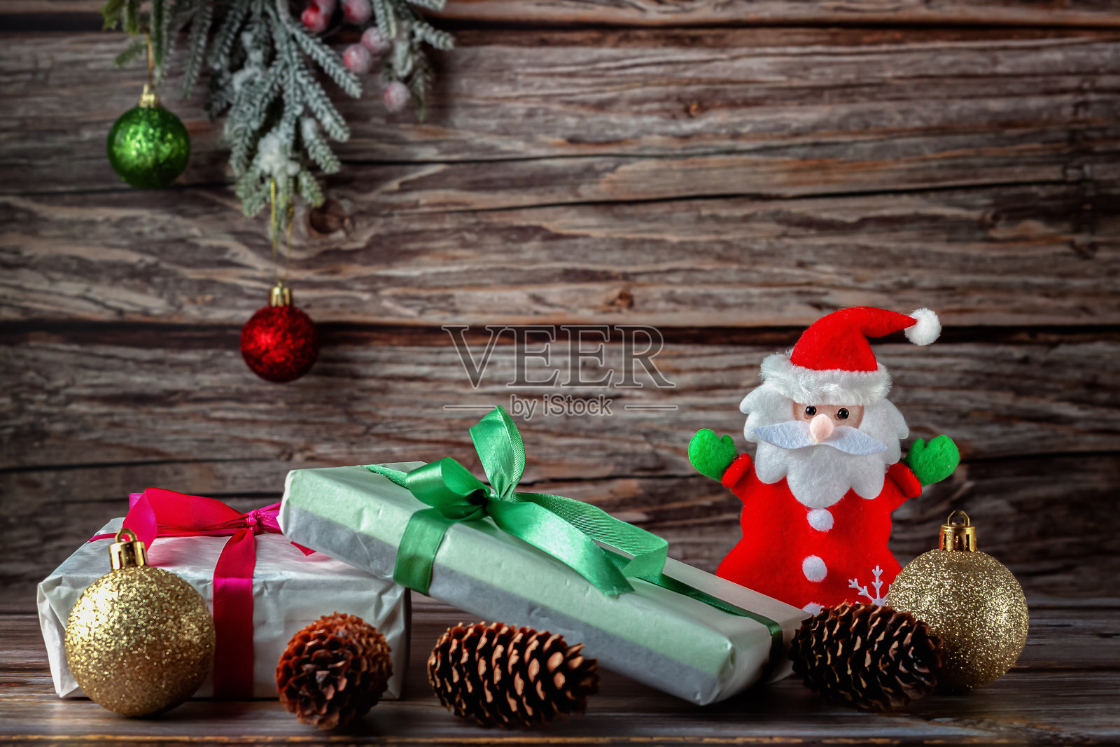 圣诞老人带着圣诞礼物，背景是一棵深色的云杉树枝照片摄影图片