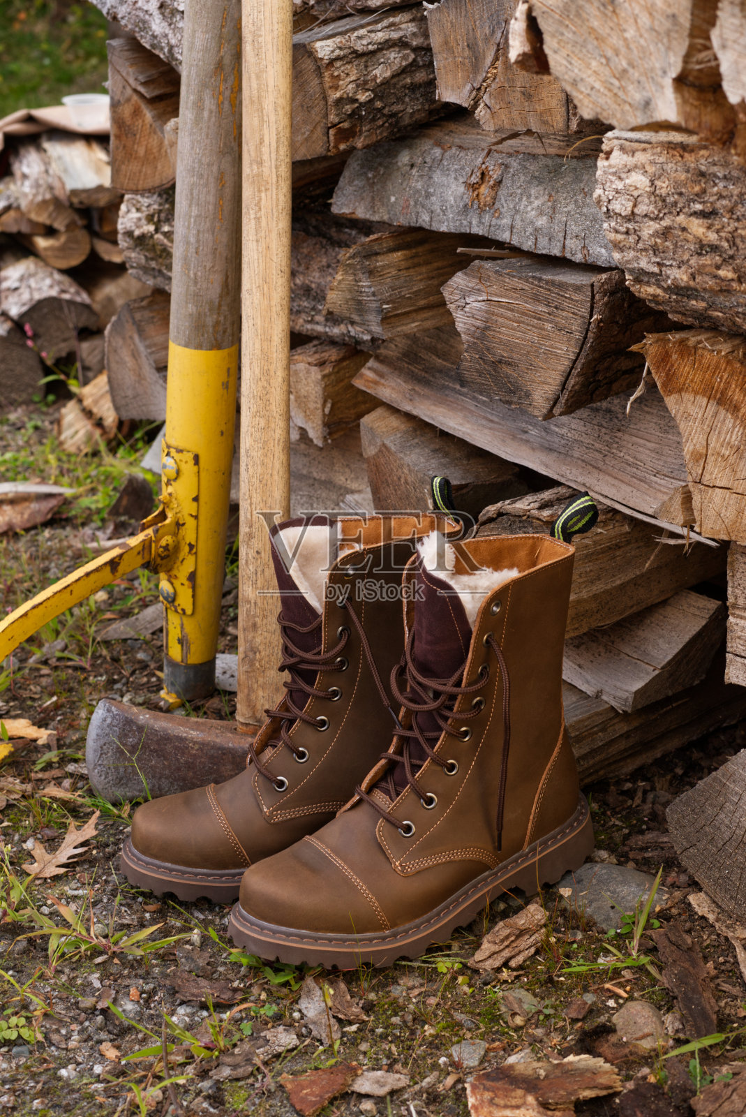 工作靴在柴堆旁照片摄影图片