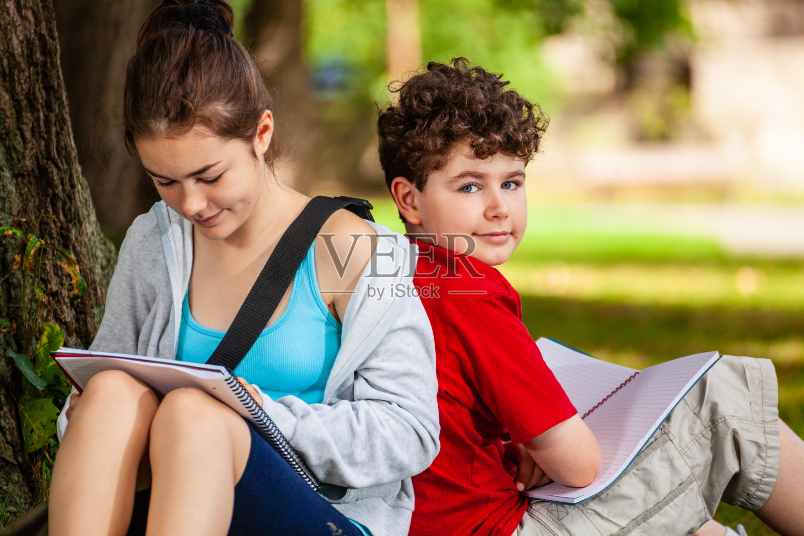 女孩和男孩在公园里学习照片摄影图片