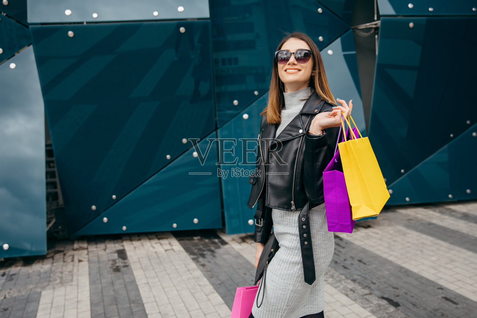 瘦削漂亮的年轻女人与购物袋走在购物中心展示照片摄影图片